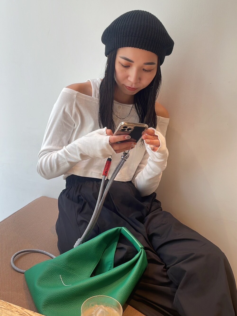 ゴールド系のパンプス、グリーン系のショルダーバッグ、ホワイト系のTシャツ/カットソーを着用したレディースの秋コーディネートの5枚目の写真