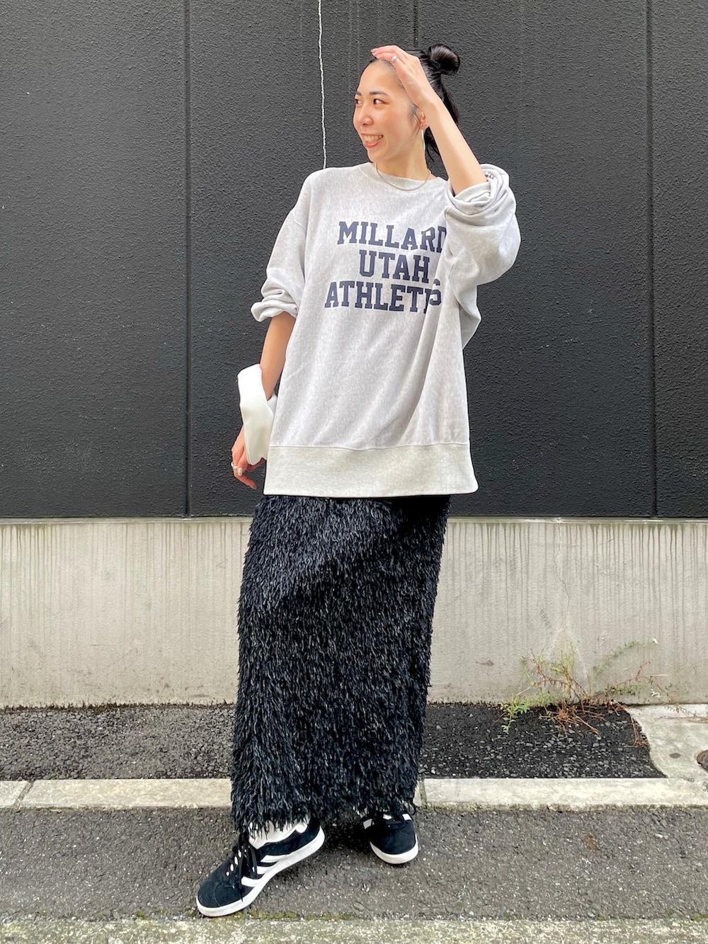 ブラック系のスカート、グレー系のスウェット、ブラック系のスニーカーを着用したレディースの秋コーディネートの4枚目の写真