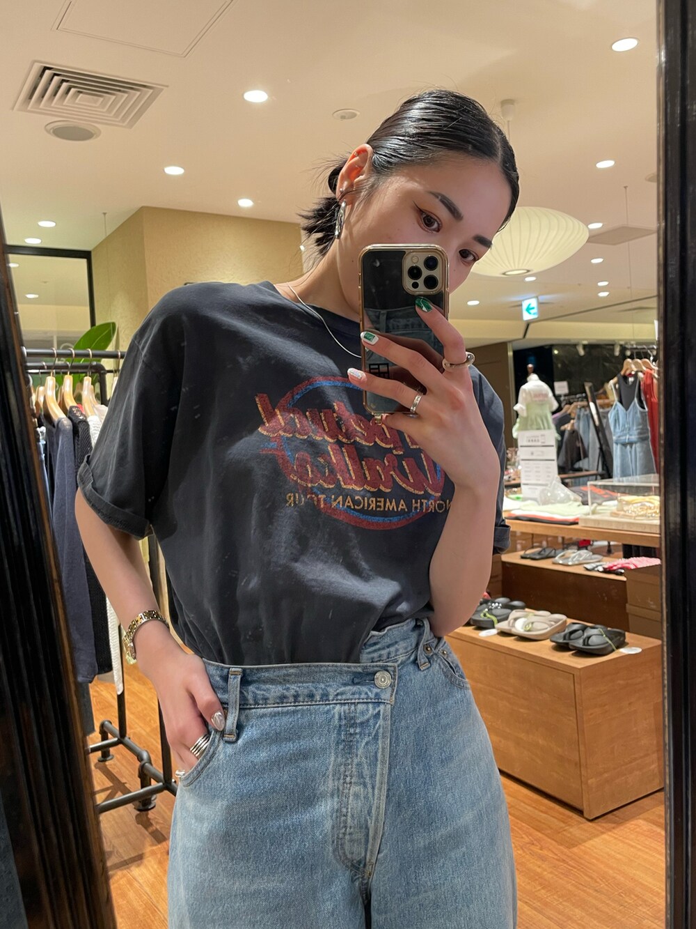 グレー系のTシャツ/カットソー、ブルー系のデニムパンツ、ゴールド系のパンプスを着用したレディースの春コーディネートの4枚目の写真