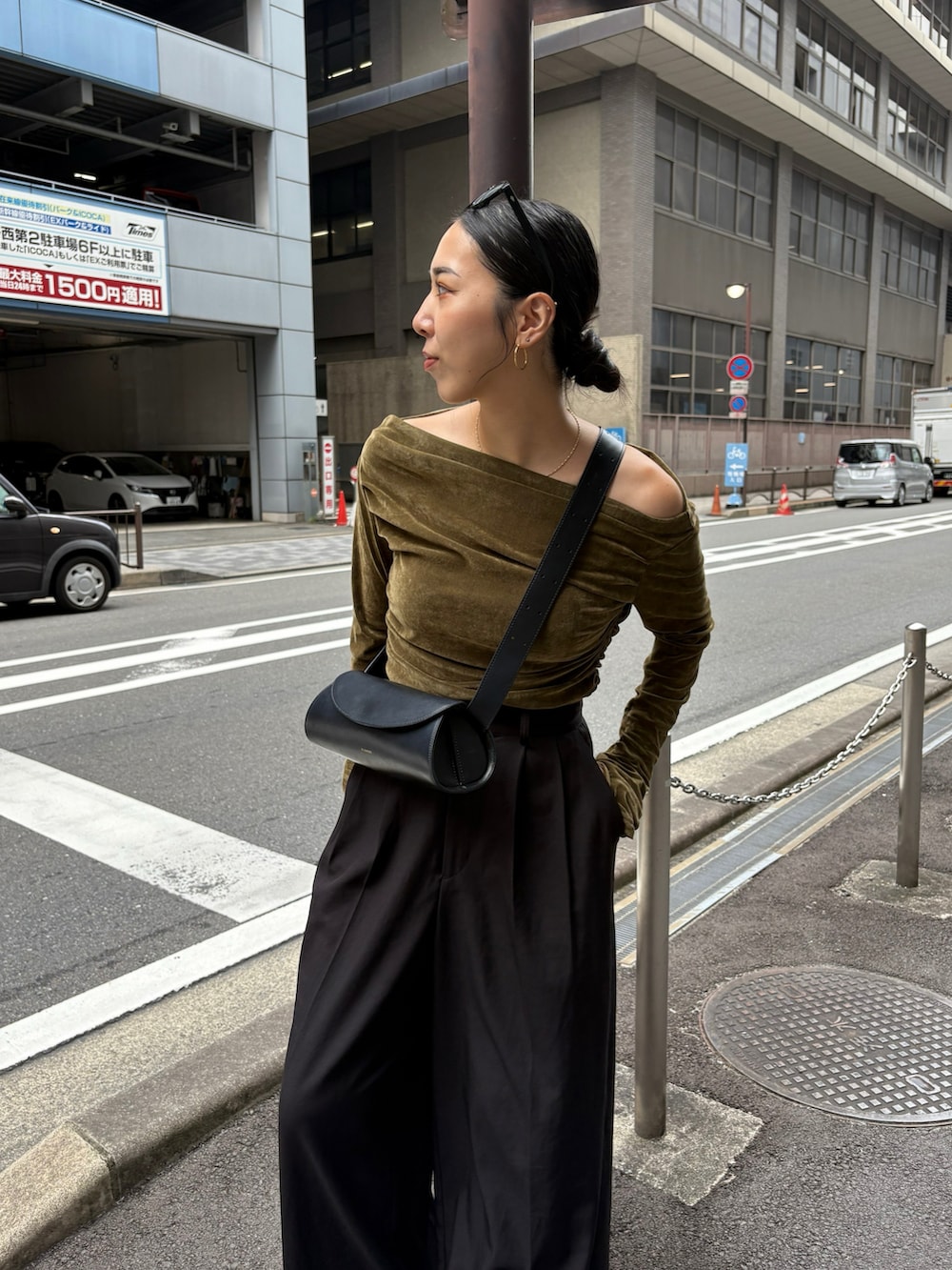 ブラック系のスラックス、ブラック系のショルダーバッグ、ブラック系のブーツを着用したレディースの秋コーディネートの5枚目の写真