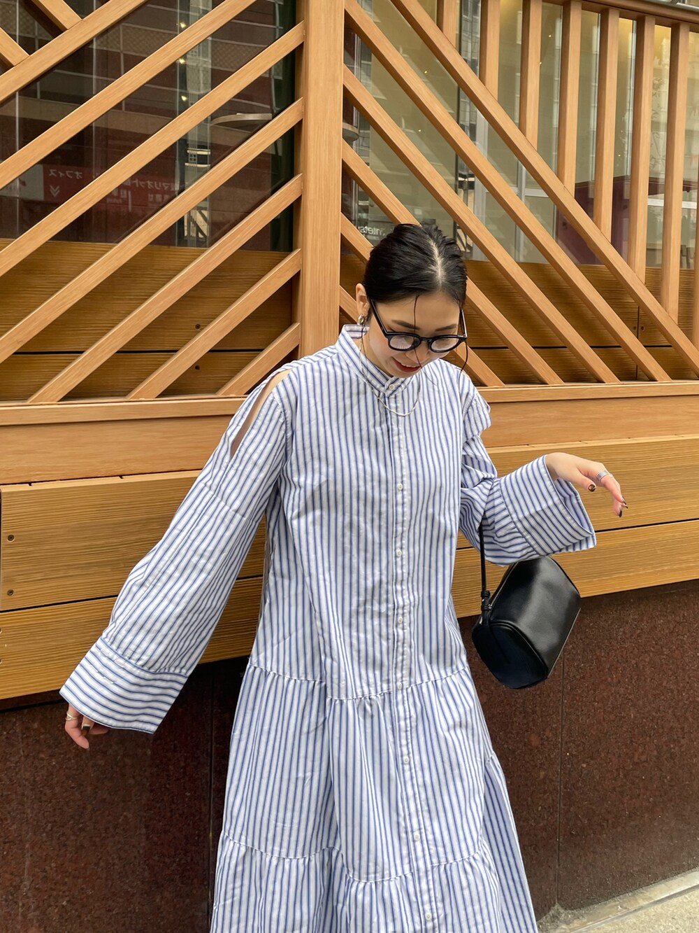 ブラック系のハンドバッグ、ホワイト系のスニーカー、その他のワンピースを着用したレディースの春コーディネートの5枚目の写真