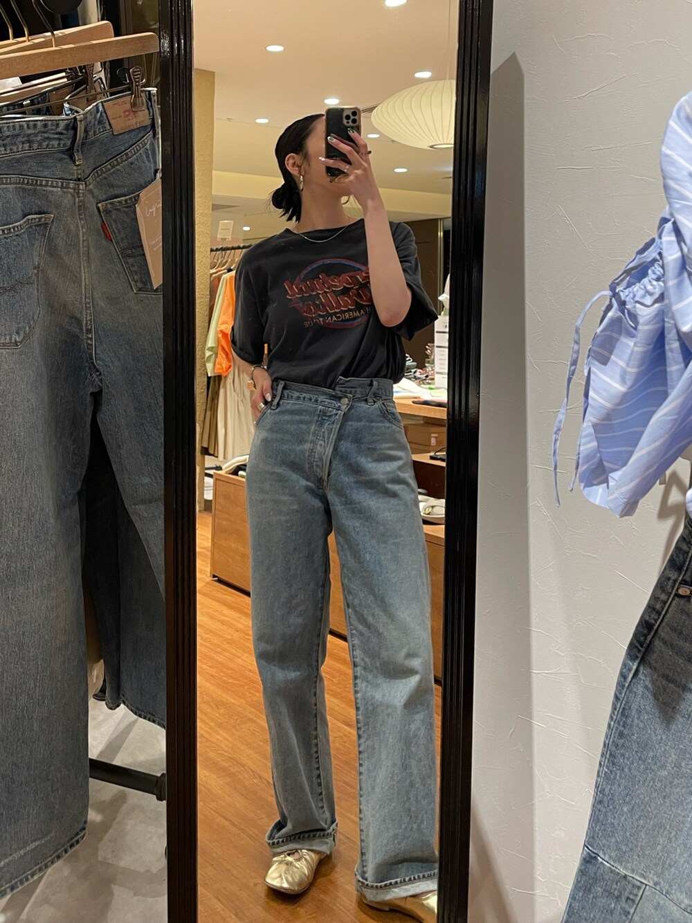 グレー系のTシャツ/カットソー、ブルー系のデニムパンツ、ゴールド系のパンプスを着用したレディースの春コーディネートの3枚目の写真