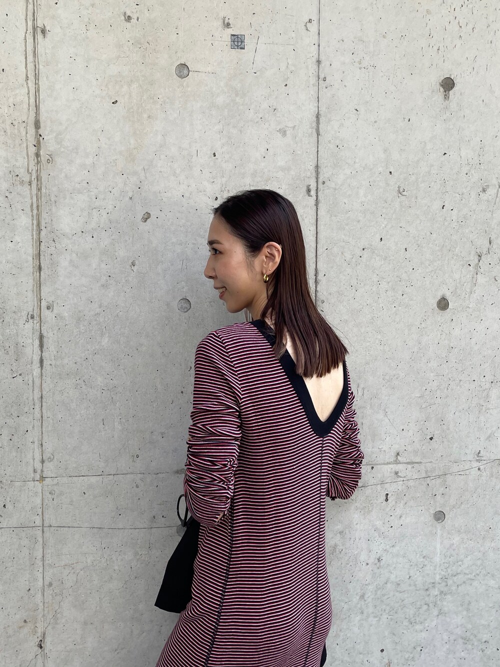 ブラック系のブルゾン、レッド系のワンピース、ブラック系のショルダーバッグを着用したレディースの夏コーディネートの4枚目の写真