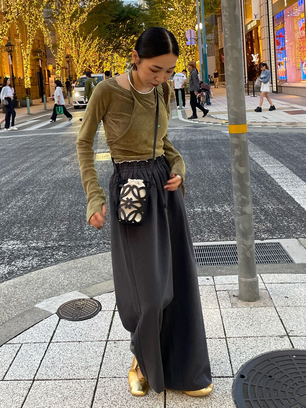 グレー系のその他パンツ、グリーン系のTシャツ/カットソー、ゴールド系のパンプスを着用したレディースの秋コーディネートの3枚目の写真