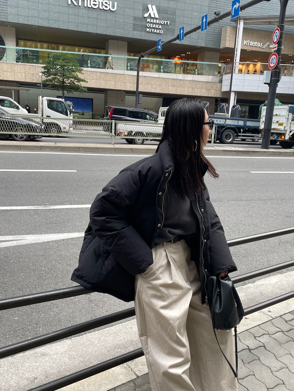 ブラック系のショルダーバッグ、ホワイト系のその他パンツ、ブラック系のダウンジャケット/コートを着用したレディースの冬コーディネートの5枚目の写真