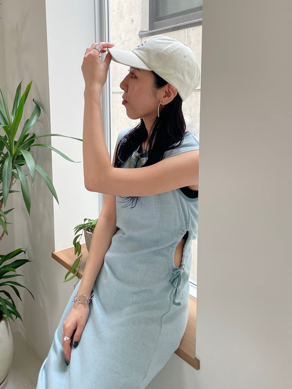 ブルー系のワンピース、ホワイト系のサンダル、ホワイト系のキャップを着用したレディースの春コーディネートの4枚目の写真