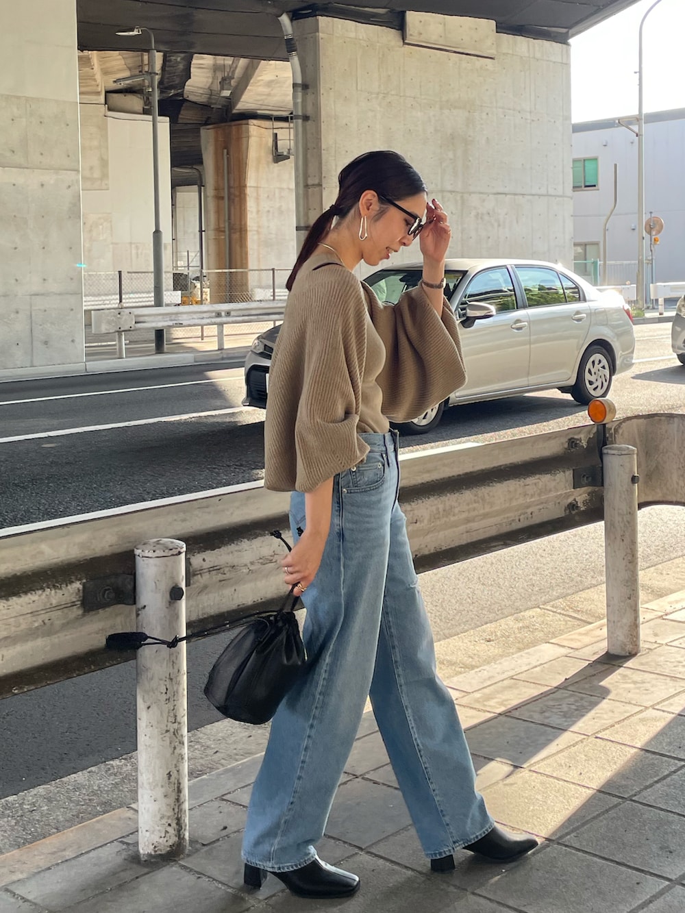 ベージュ系のカーディガン/ボレロ、ブラック系のハンドバッグ、ブラック系のブーツを着用したレディースの秋コーディネートの2枚目の写真