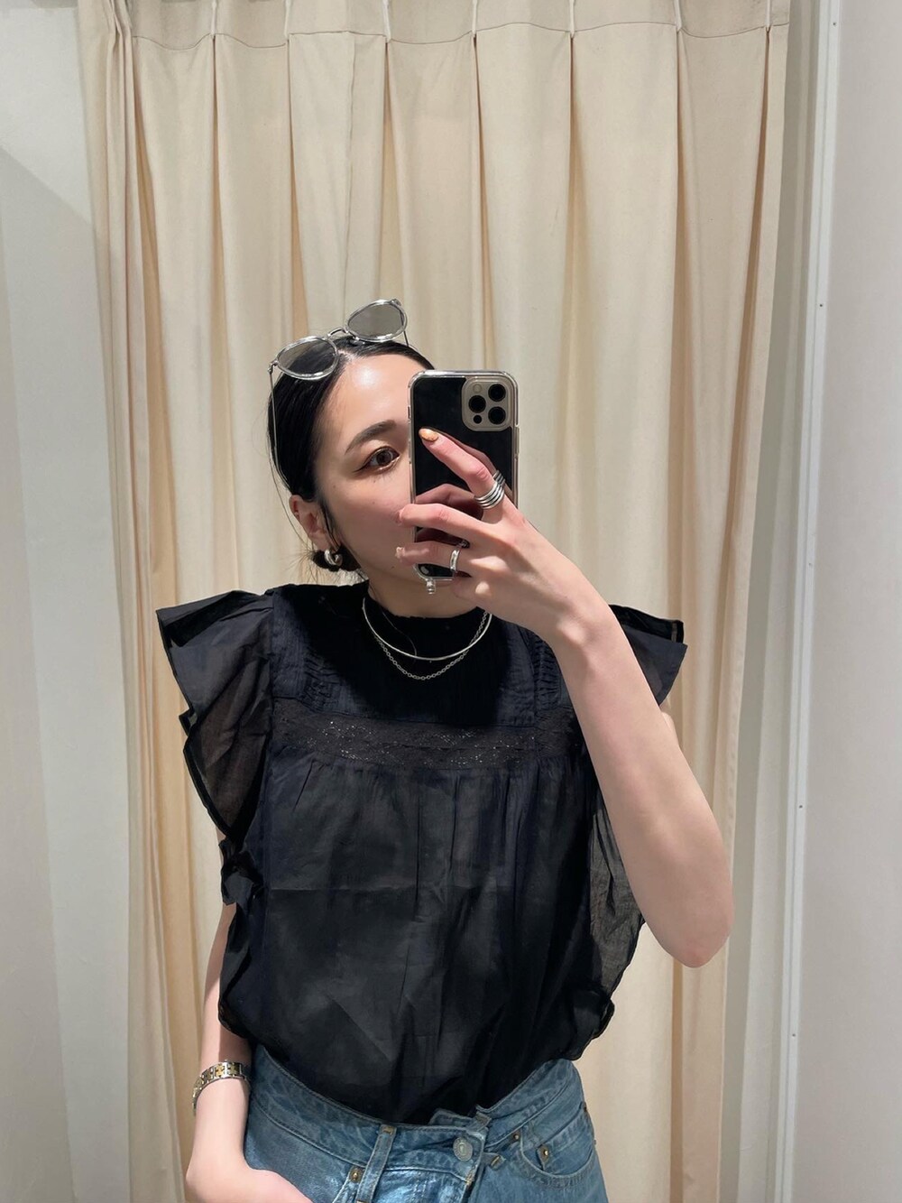 ブラック系のサンダル、ブルー系のデニムパンツ、ブラック系のシャツ/ブラウスを着用したレディースの春コーディネートの4枚目の写真