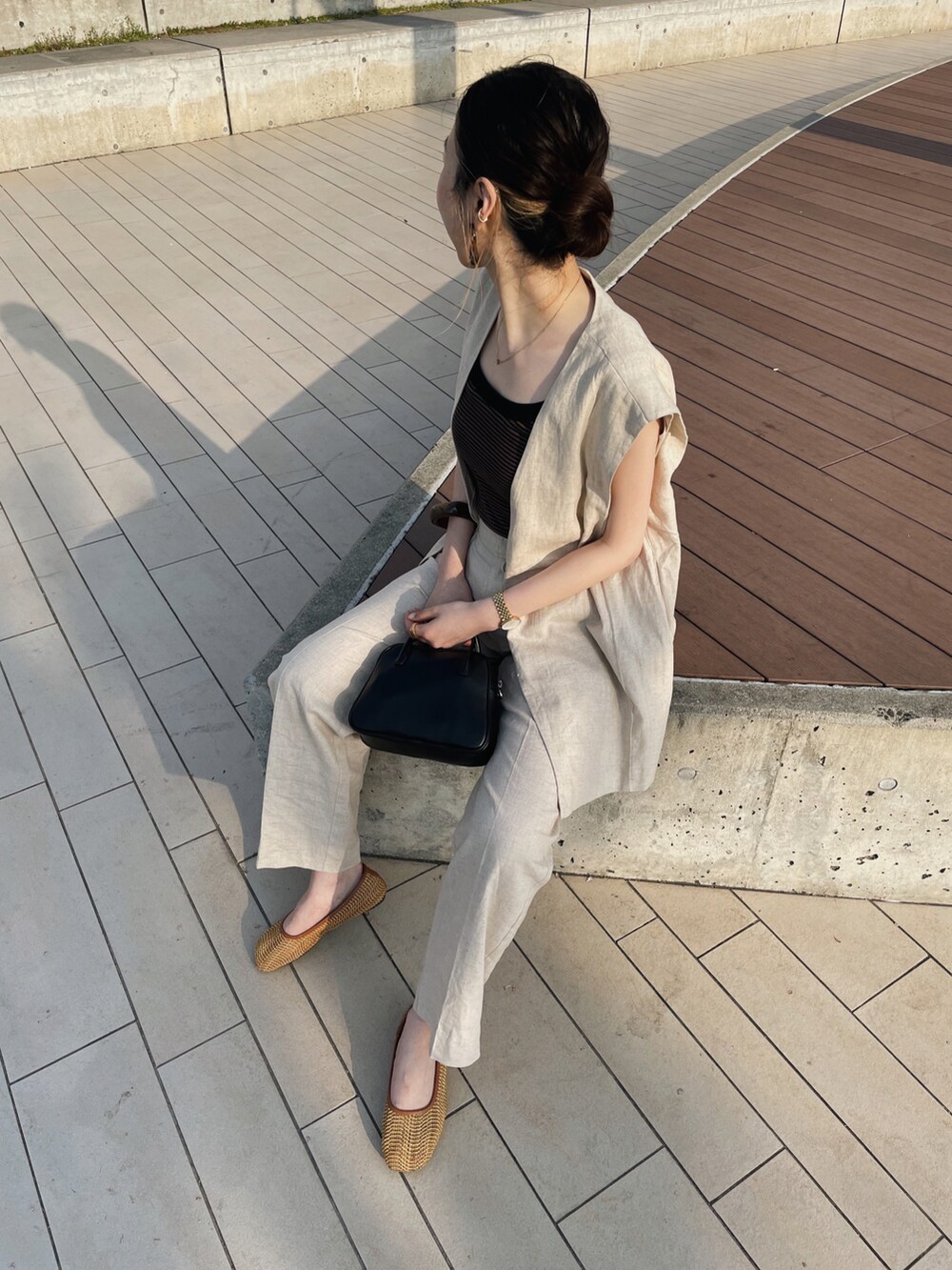 ブラウン系のタンクトップ、ホワイト系のベスト、ホワイト系のその他パンツを着用したレディースの春コーディネートの2枚目の写真