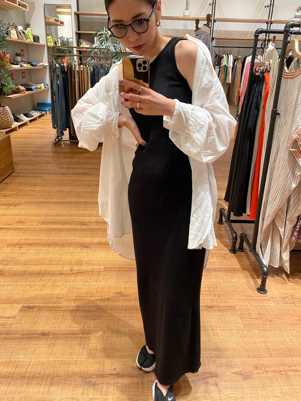 ブラック系のワンピース、ホワイト系のシャツ/ブラウス、ブラック系のスニーカーを着用したレディースの夏コーディネートの4枚目の写真