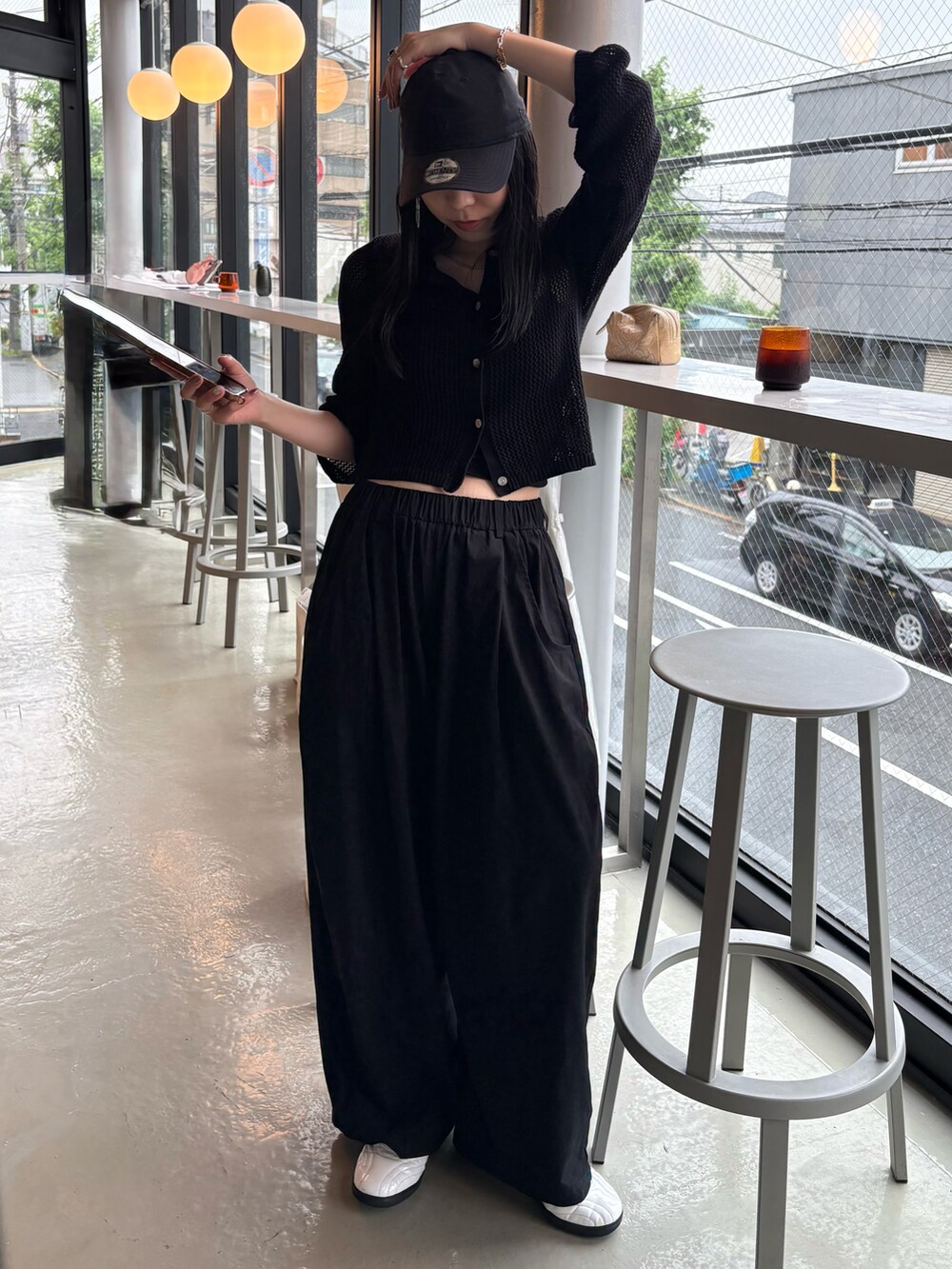 ホワイト系のスニーカー、ブラック系のカーディガン/ボレロ、ブラック系のキャップを着用したレディースの夏コーディネートの3枚目の写真