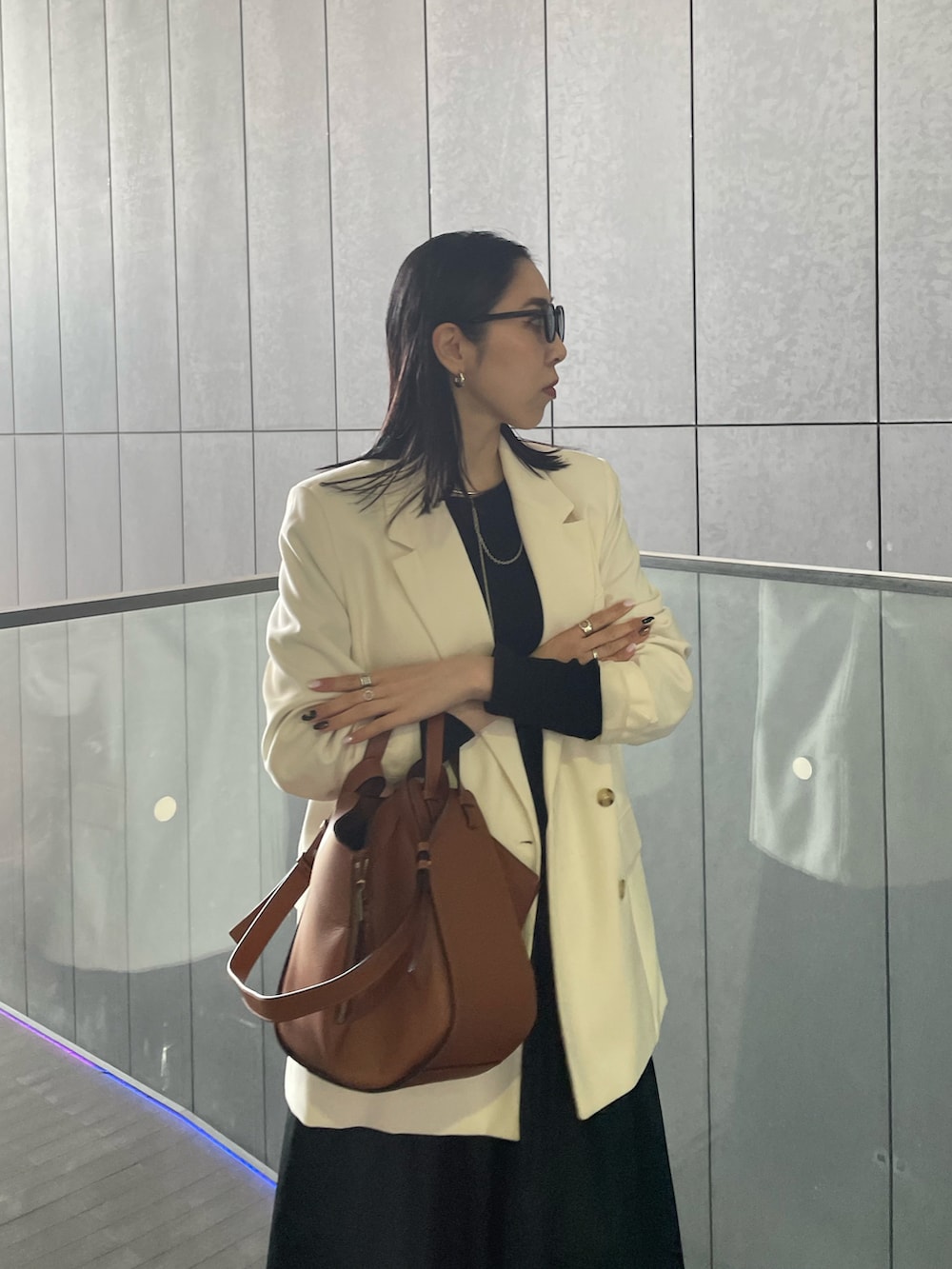 ブラウン系のバックパック/リュック、ゴールド系のパンプス、ブラック系のTシャツ/カットソーを着用したレディースの春コーディネートの4枚目の写真