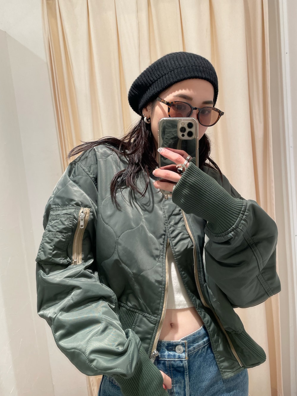 ブルー系のデニムパンツ、ベージュ系のMA-1、ブラック系のハンチング/ベレー帽を着用したレディースの秋コーディネートの4枚目の写真