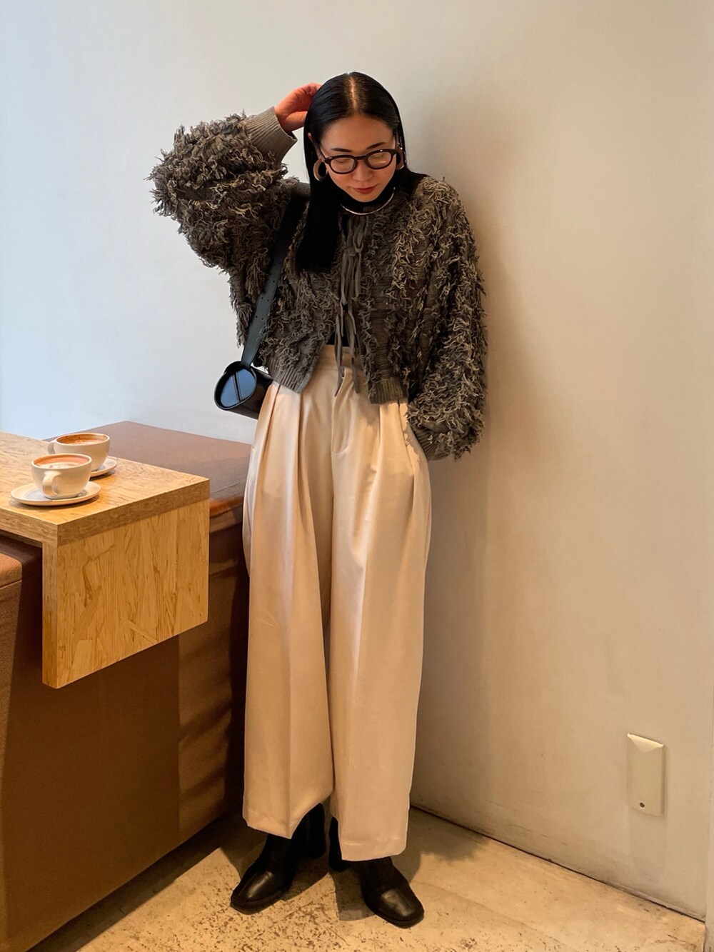 ホワイト系のその他パンツ、ブラック系のブーツ、グレー系のニット/セーターを着用したレディースの秋コーディネートの2枚目の写真