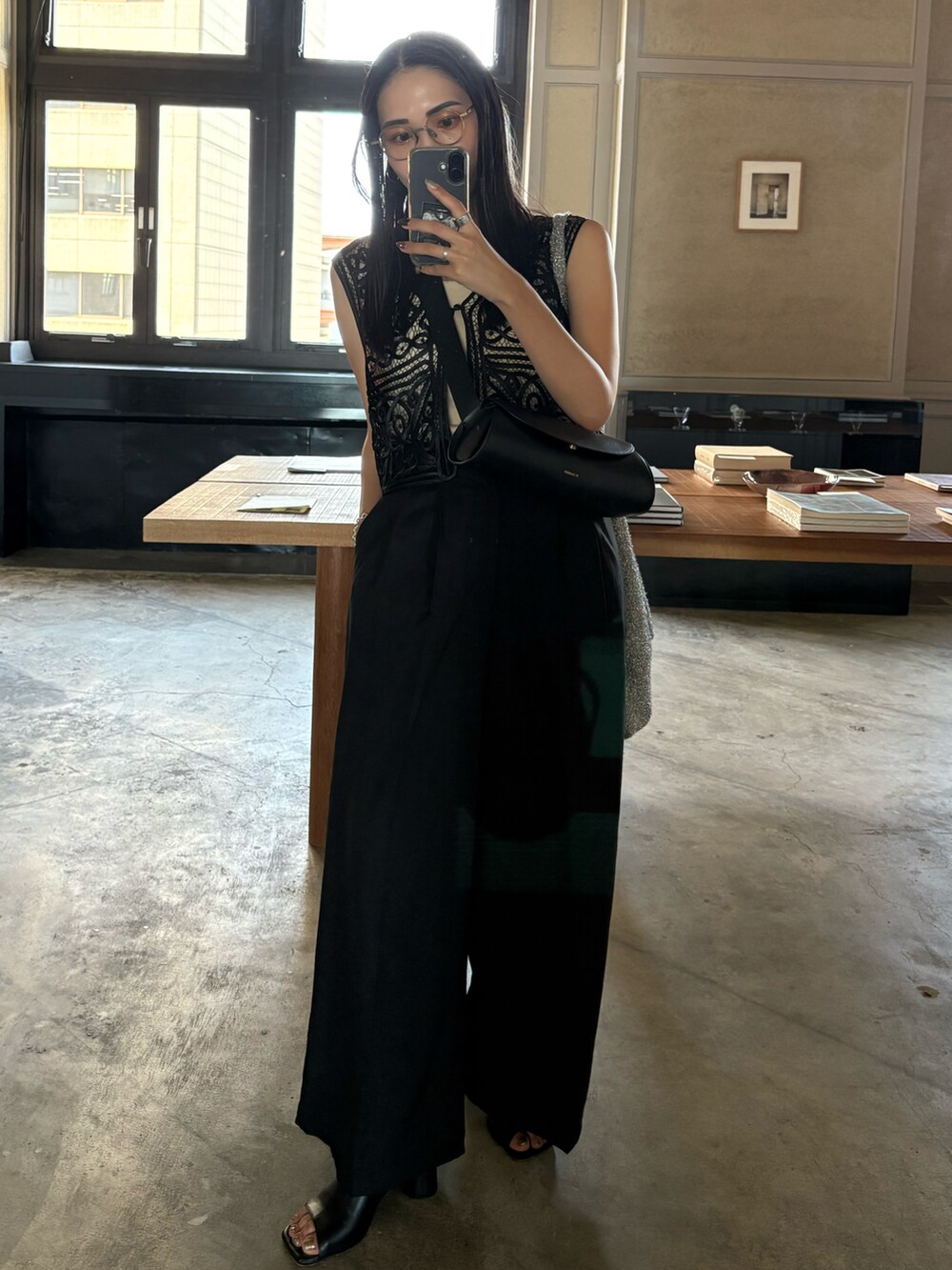 ブラック系のサンダル、ブラック系のスラックス、ブラック系のベストを着用したレディースの夏コーディネートの2枚目の写真