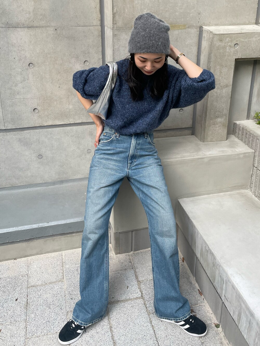 ブルー系のニット/セーター、ブルー系のデニムパンツ、ブラック系のスニーカーを着用したレディースの秋コーディネートの3枚目の写真