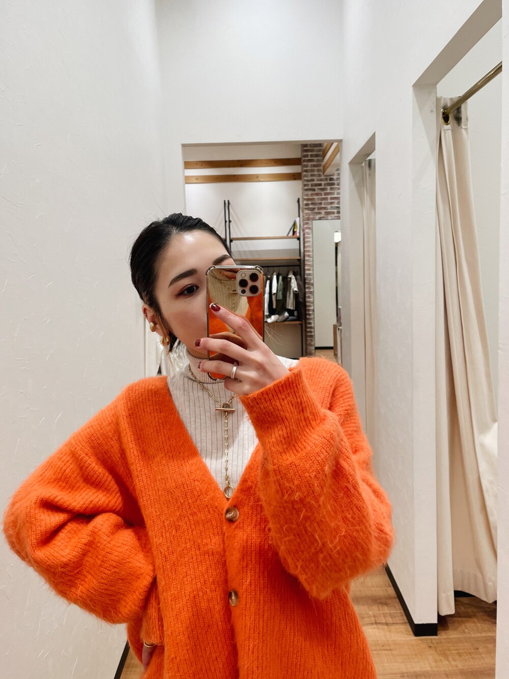 ホワイト系のニット/セーター、ホワイト系のその他パンツ、オレンジ系のカーディガン/ボレロを着用したレディースの冬コーディネートの2枚目の写真