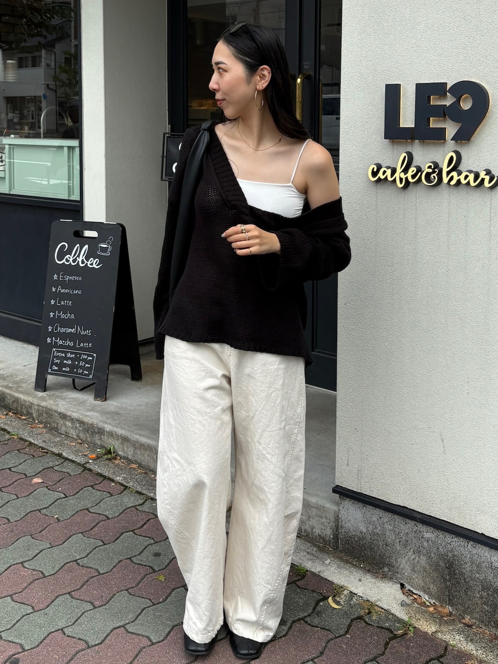 ブラック系のハンドバッグ、ブラック系のブーツを着用したレディースの夏コーディネートの3枚目の写真