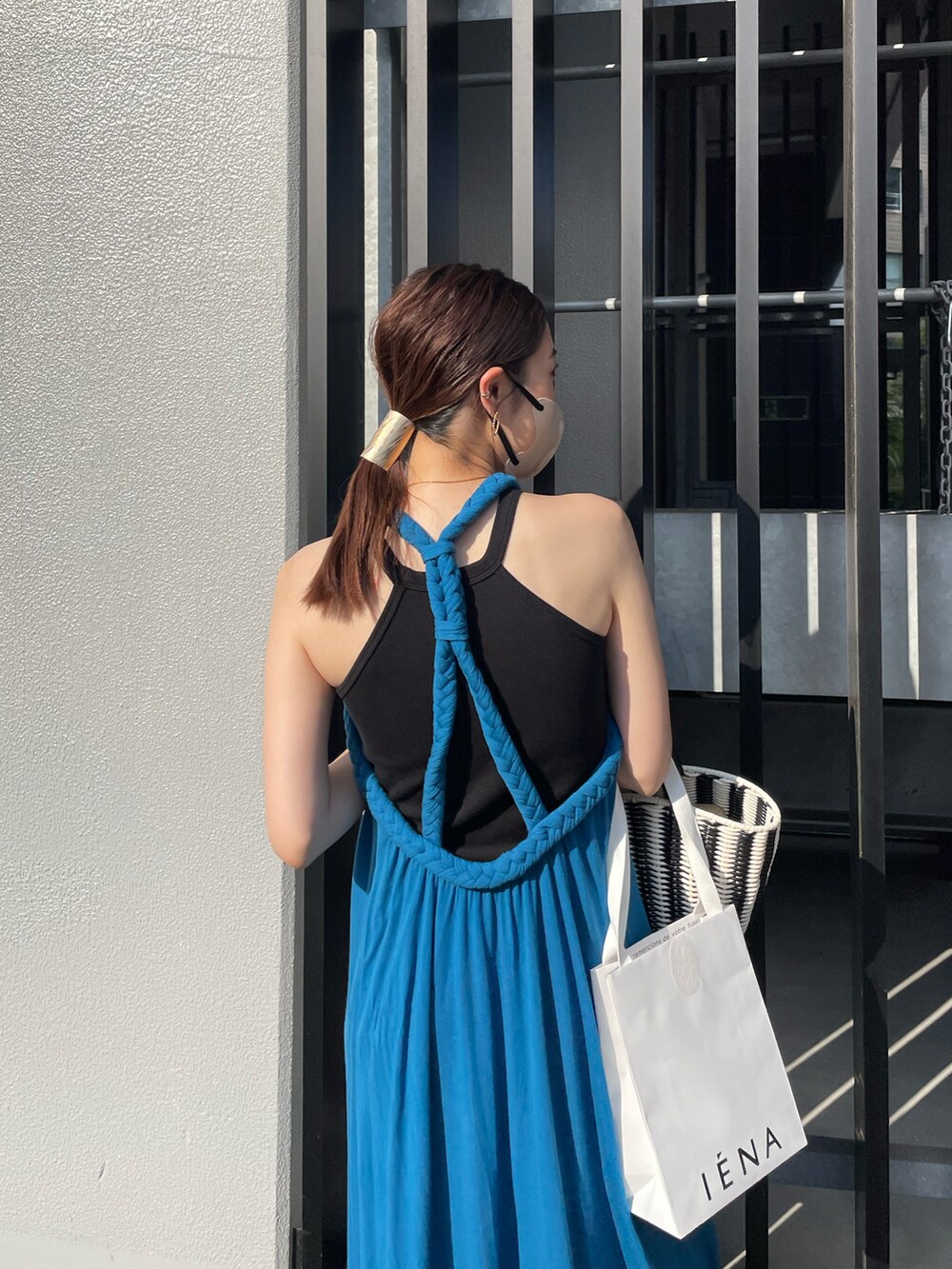 ブルー系のワンピース、ブラック系のハンドバッグを着用したレディースの夏コーディネートの5枚目の写真