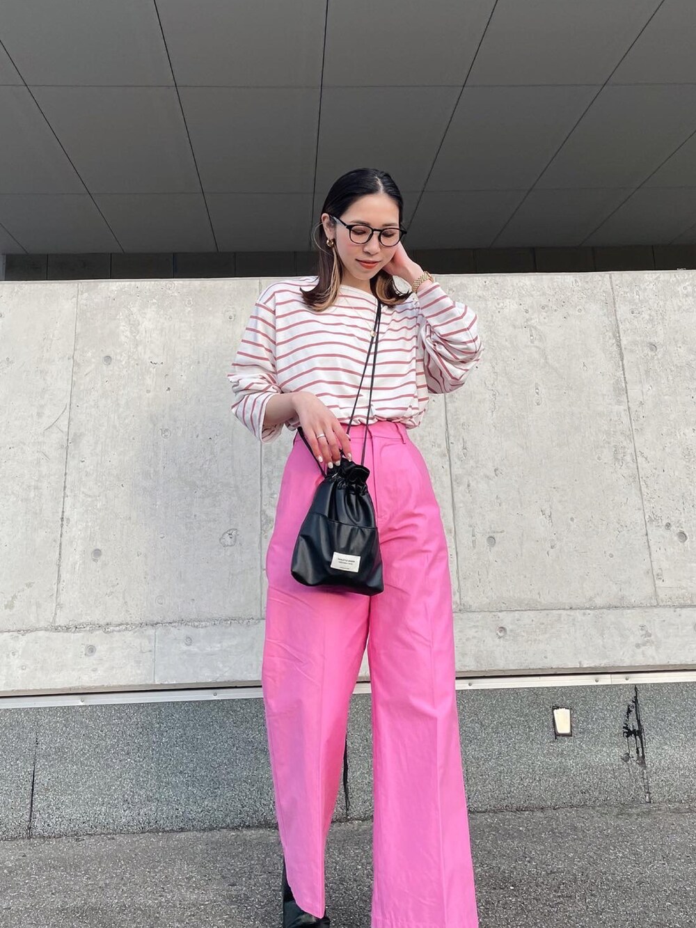 ピンク系のTシャツ/カットソー、ピンク系のスラックス、ブラック系のブーツを着用したレディースの冬コーディネートの2枚目の写真