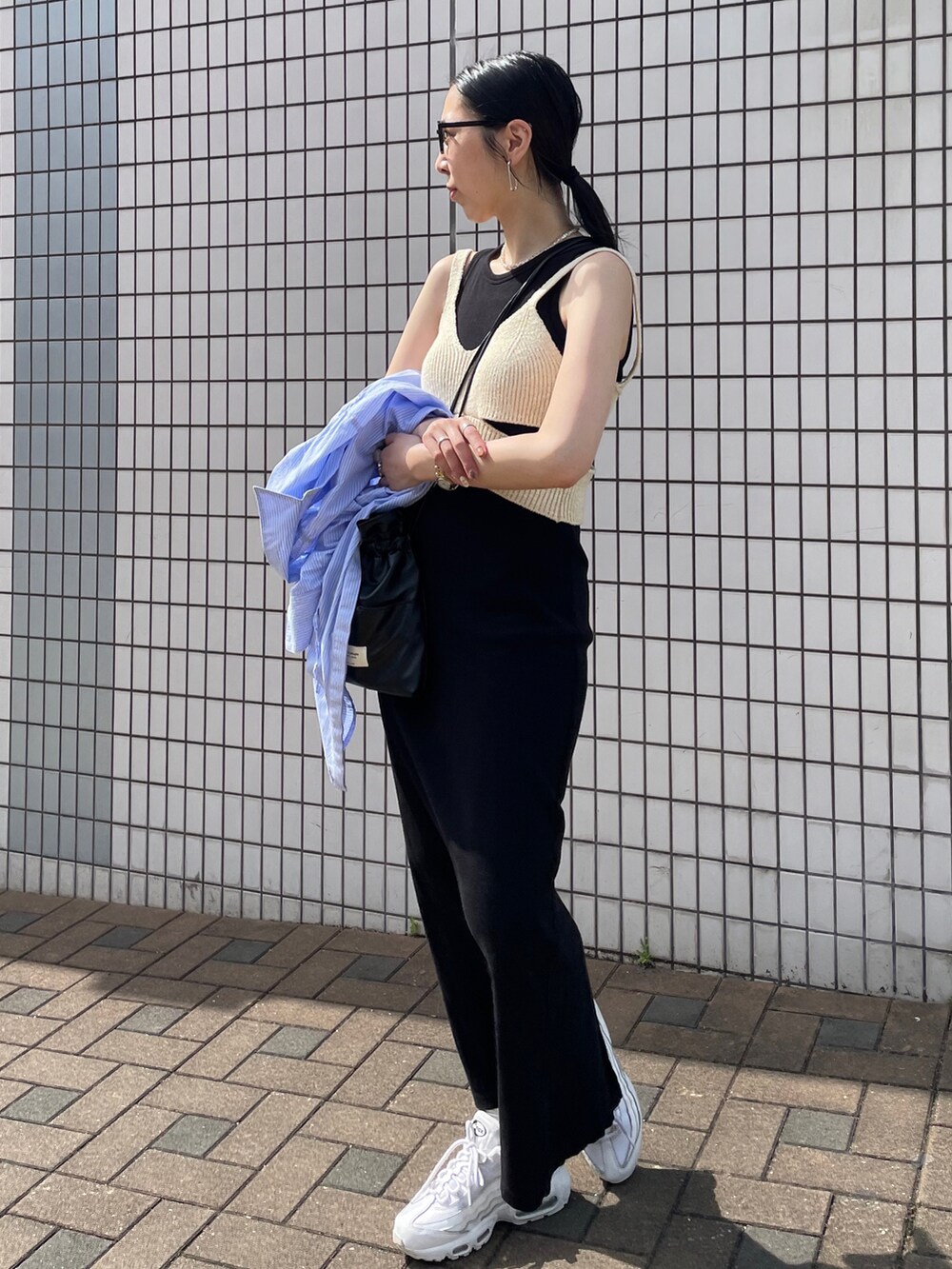 ブラック系のワンピース、ホワイト系のニット/セーター、ホワイト系のスニーカーを着用したレディースの夏コーディネートの2枚目の写真