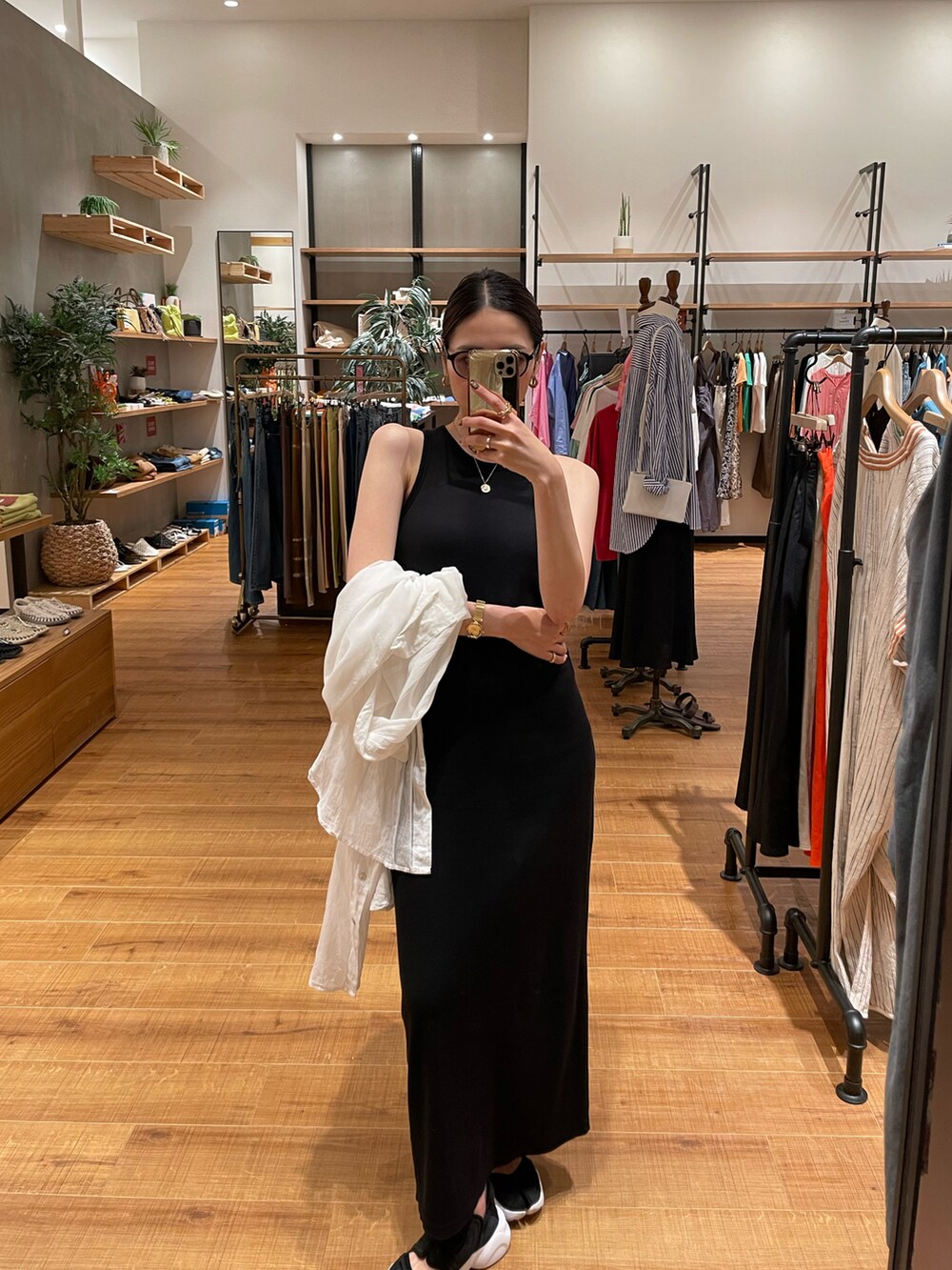 ブラック系のワンピース、ホワイト系のシャツ/ブラウス、ブラック系のスニーカーを着用したレディースの夏コーディネートの2枚目の写真