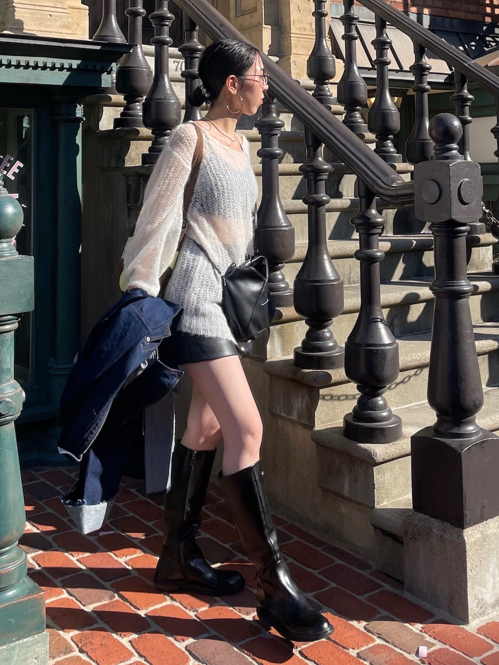 ホワイト系のニット/セーター、ブラック系のショルダーバッグ、グレー系のサングラスを着用したレディースの秋コーディネートの2枚目の写真