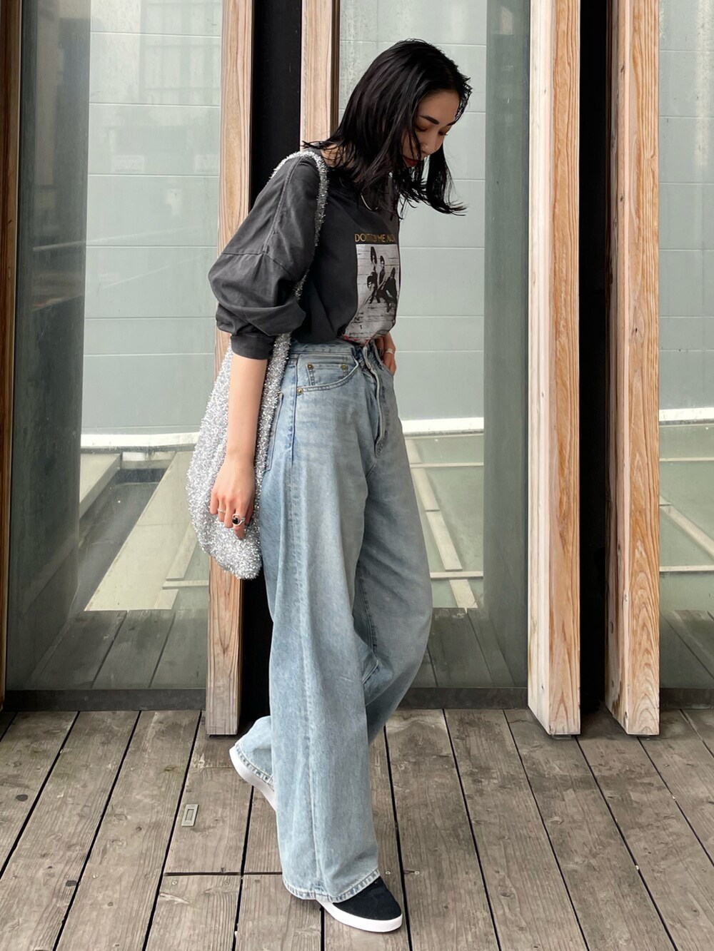 ブラック系のスニーカー、ブルー系のデニムパンツ、グレー系のTシャツ/カットソーを着用したレディースの春コーディネートの5枚目の写真