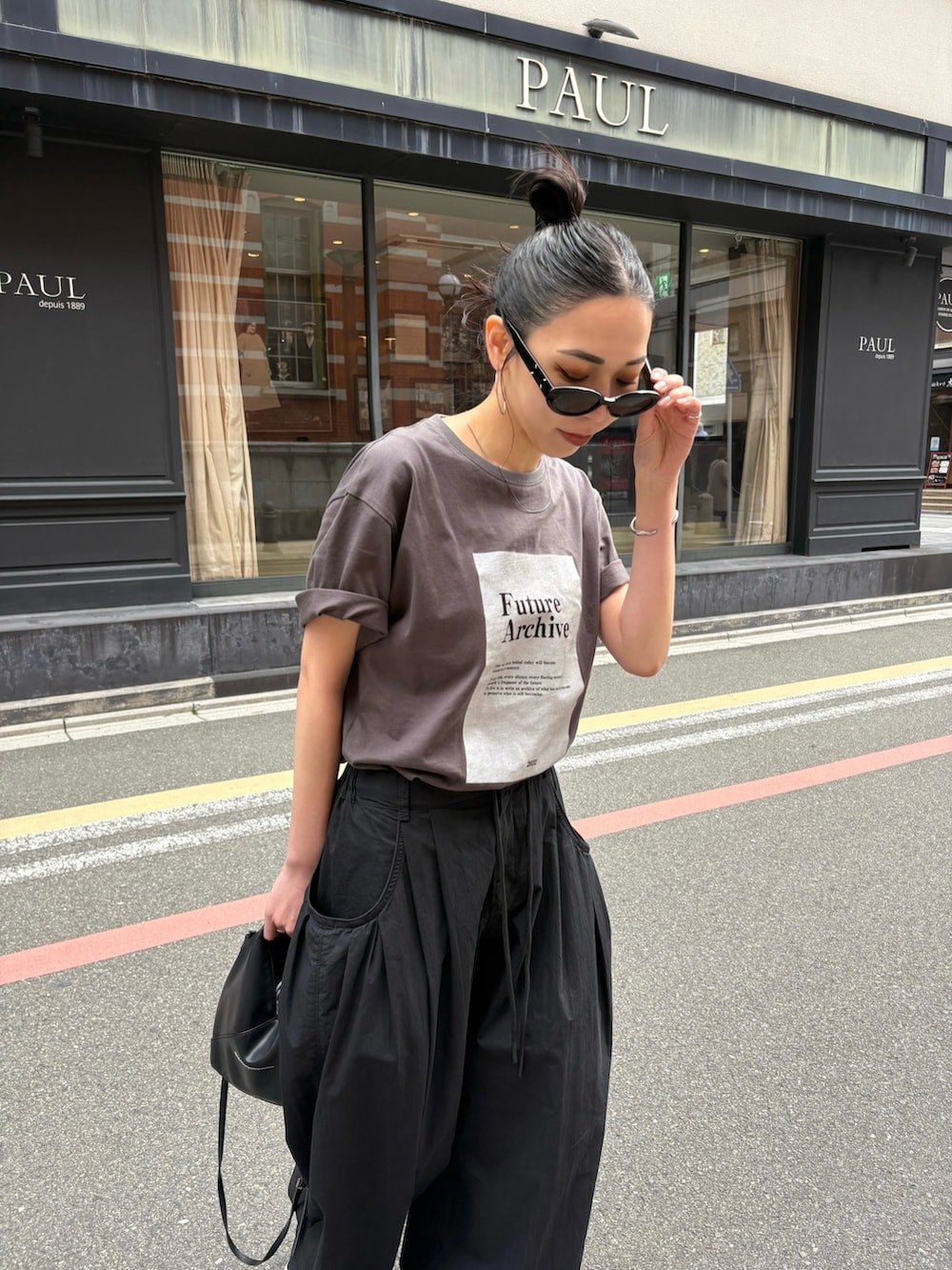 ブラック系のスニーカーを着用したレディースの春コーディネートの3枚目の写真