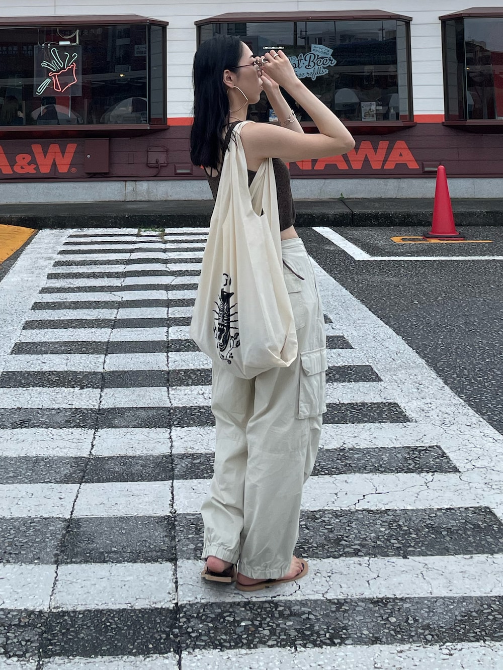 ホワイト系のカーゴパンツ、ブラック系のサンダル、ブラック系のショルダーバッグを着用したレディースの秋コーディネートの5枚目の写真