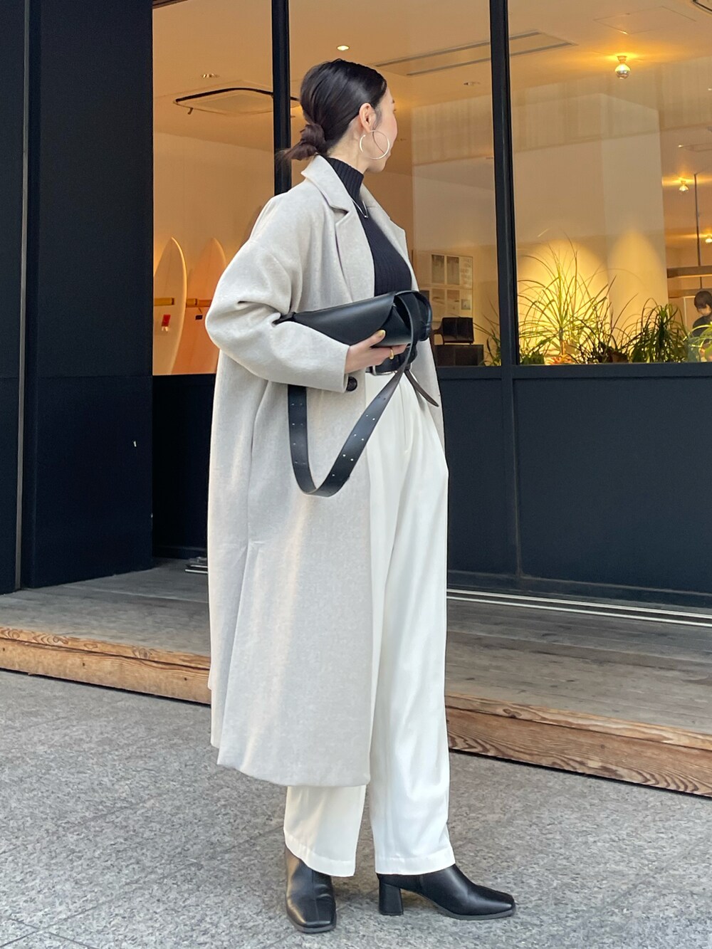 ブラック系のショルダーバッグ、ブラック系のブーツ、ブラック系のニット/セーターを着用したレディースの冬コーディネートの2枚目の写真