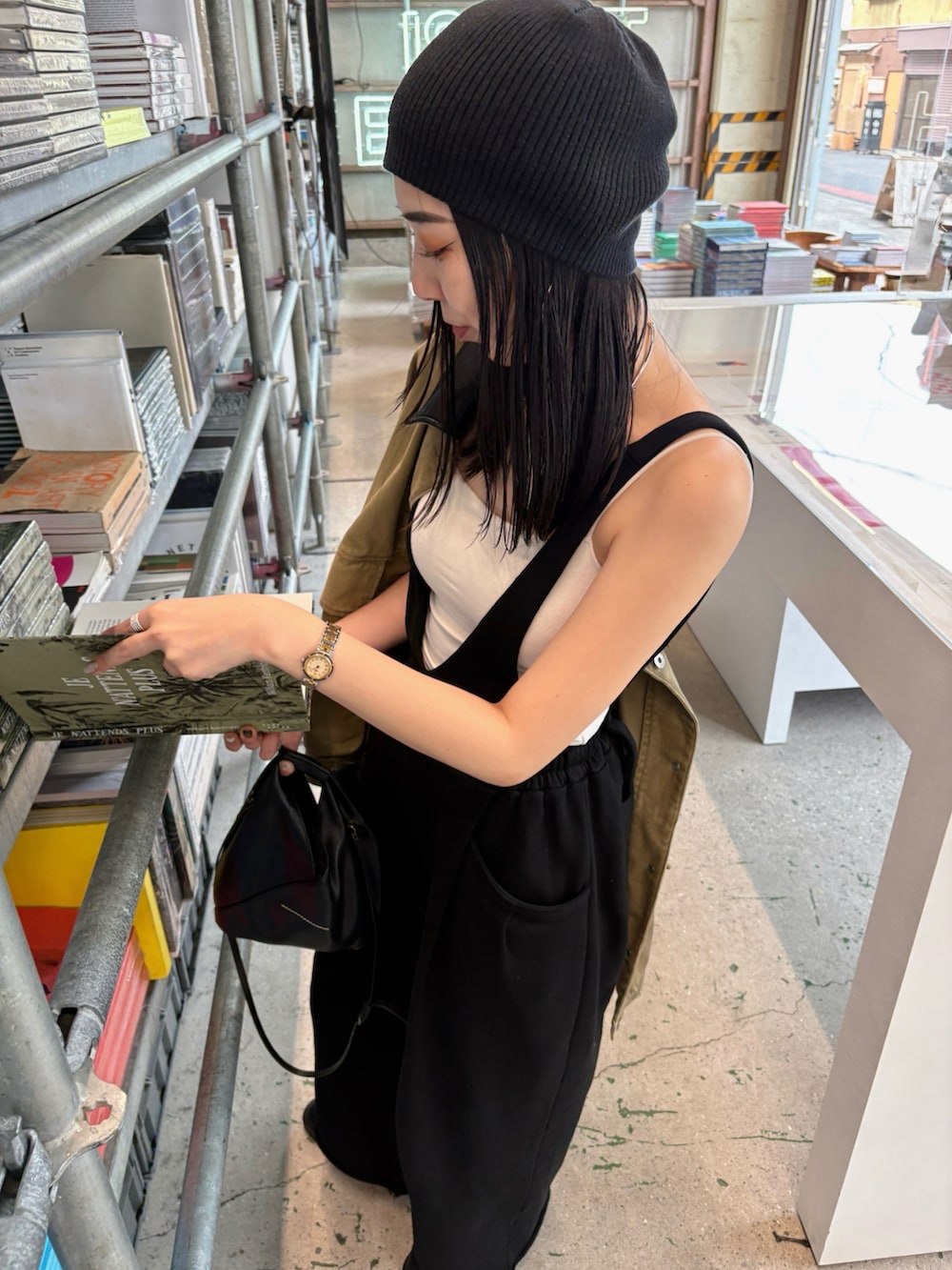 ブラック系のショルダーバッグ、ブラック系のブーツ、ブラック系のニットキャップ/ビーニーを着用したレディースの春コーディネートの5枚目の写真