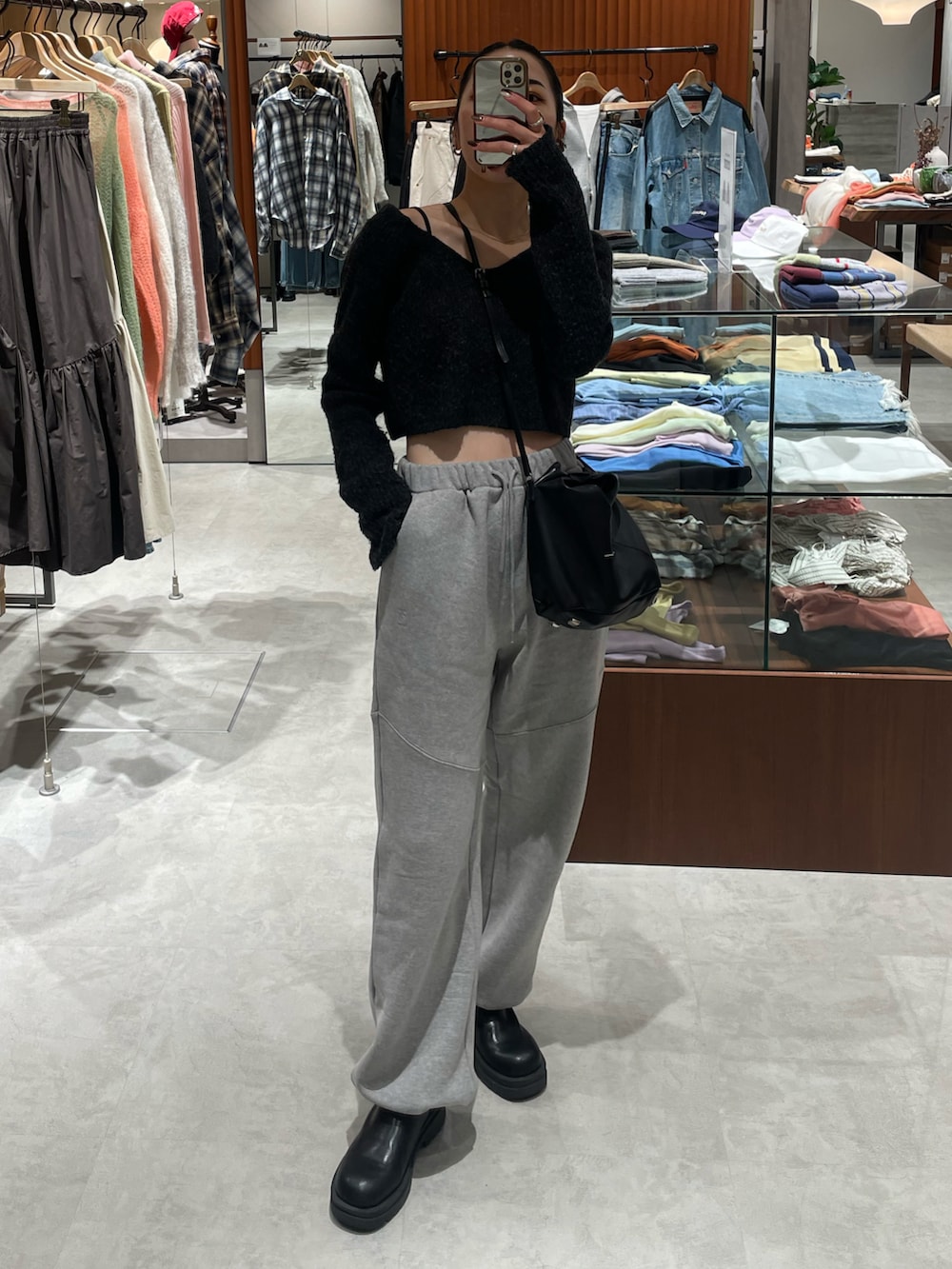 ブラック系のブーツ、グレー系のニット/セーター、ブラック系のショルダーバッグを着用したレディースの秋コーディネートの2枚目の写真