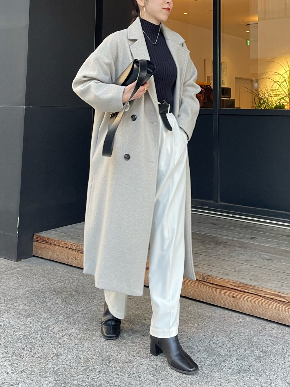 ブラック系のショルダーバッグ、ブラック系のブーツ、ブラック系のニット/セーターを着用したレディースの冬コーディネートの3枚目の写真