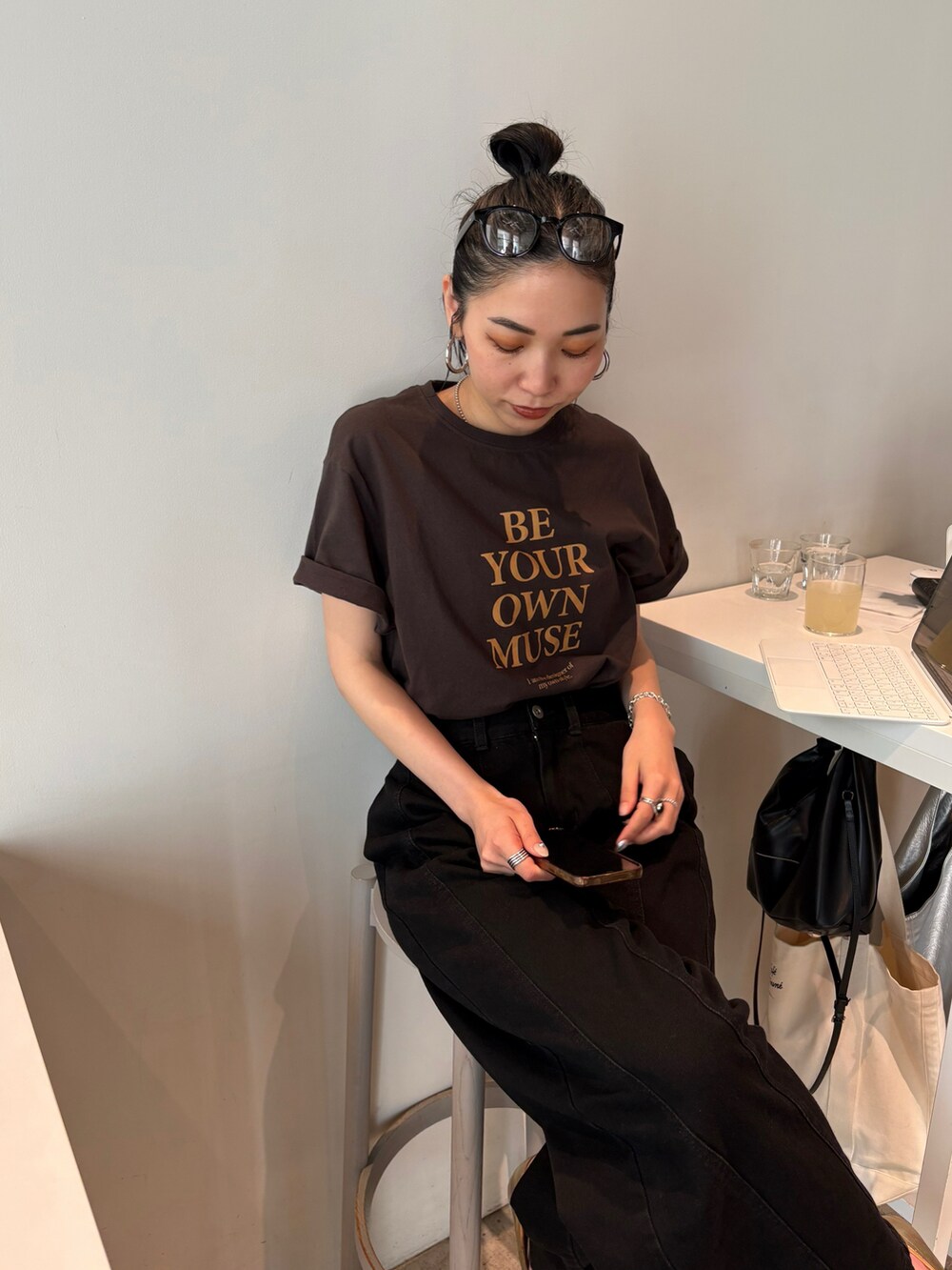 ブラック系のショルダーバッグ、ゴールド系のパンプス、シルバー系のネックレスを着用したレディースの春コーディネートの4枚目の写真