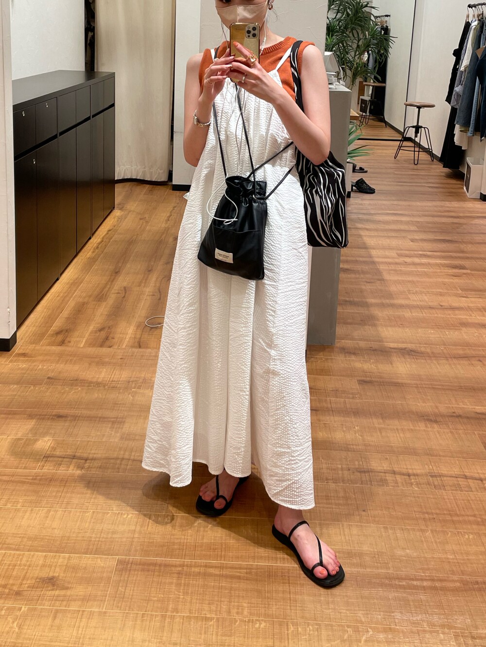 ホワイト系のワンピース、ブラック系のショルダーバッグ、ブラック系のトートバッグを着用したレディースの夏コーディネートの2枚目の写真