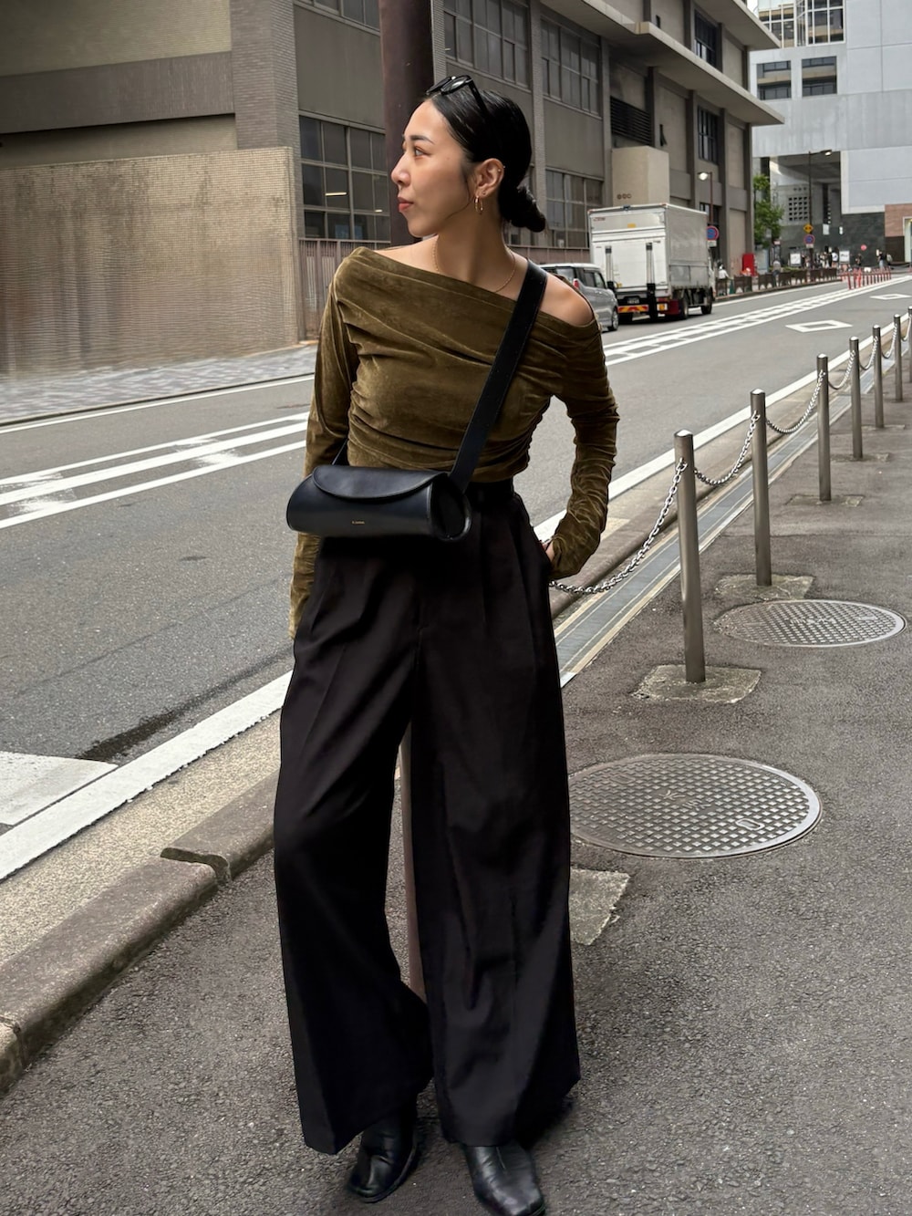 ブラック系のスラックス、ブラック系のショルダーバッグ、ブラック系のブーツを着用したレディースの秋コーディネートの4枚目の写真