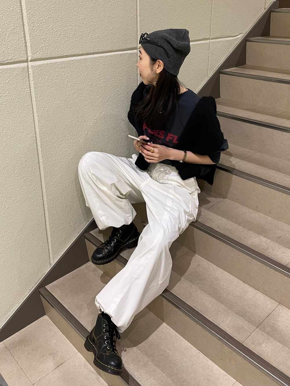 ホワイト系のカーゴパンツ、グレー系のTシャツ/カットソー、ブラック系のブーツを着用したレディースの冬コーディネートの2枚目の写真