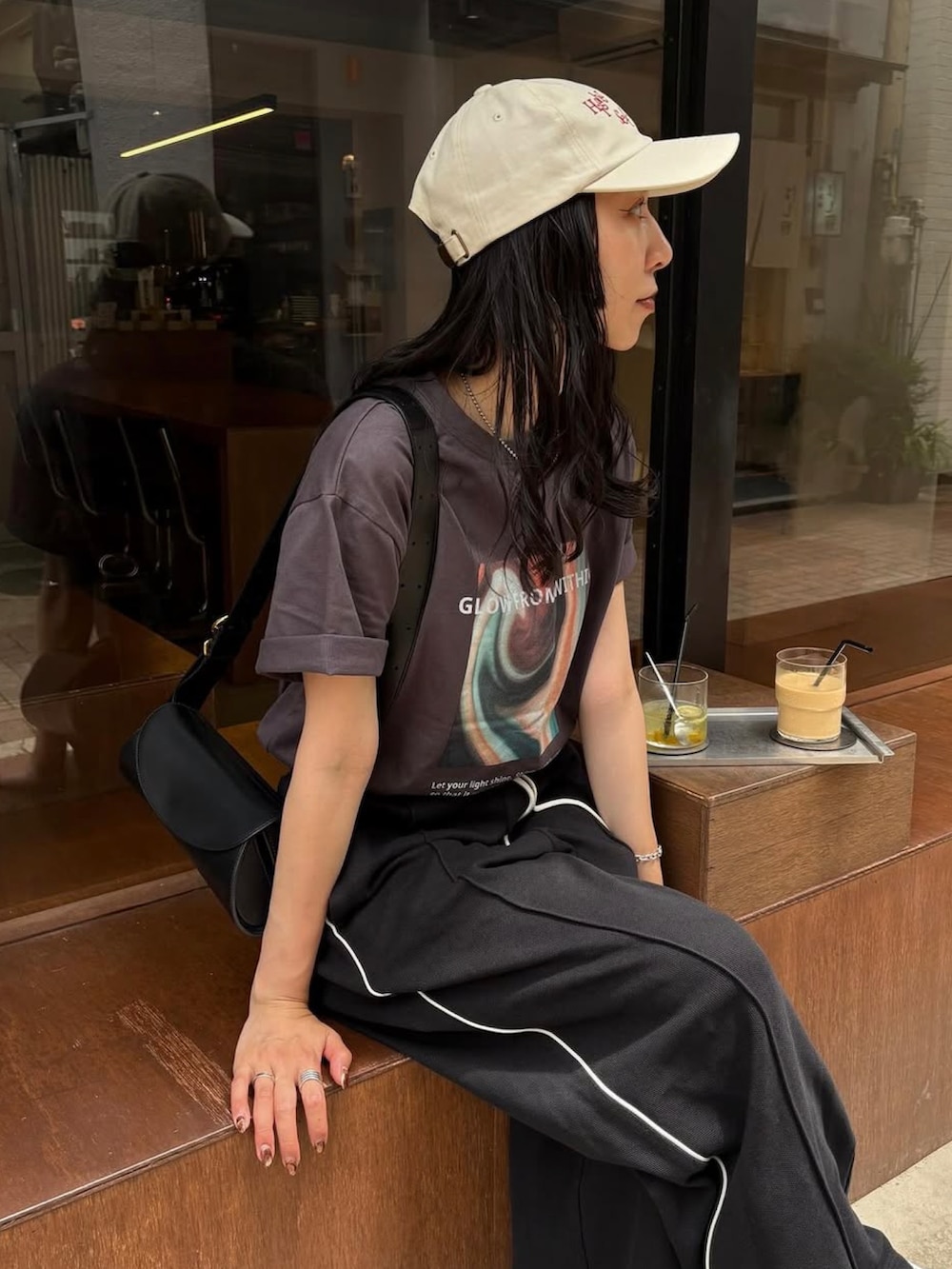 ホワイト系のスニーカー、ブラック系のショルダーバッグ、ブラック系のその他パンツを着用したレディースの夏コーディネートの2枚目の写真