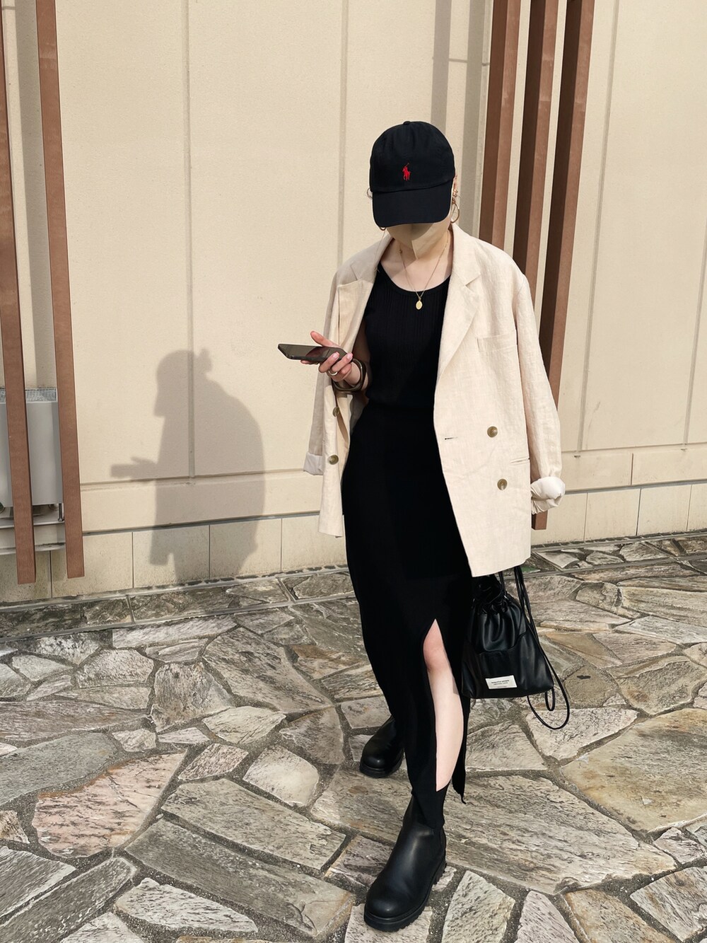 ブラック系のショルダーバッグ、ホワイト系のテーラードジャケット、ブラック系のスカートを着用したレディースの春コーディネートの4枚目の写真