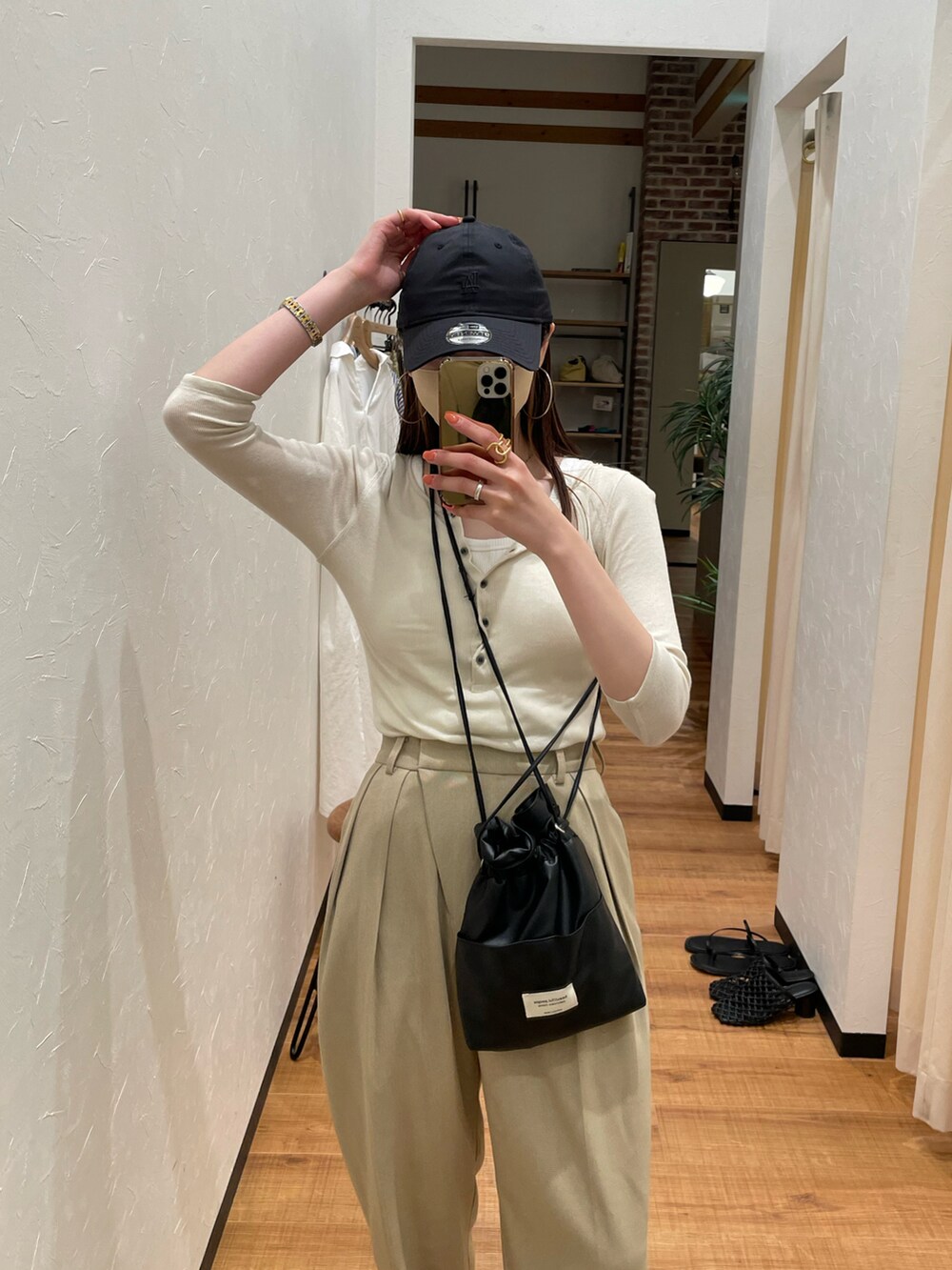 ベージュ系のTシャツ/カットソー、ベージュ系のスラックス、ブラック系のショルダーバッグを着用したレディースの夏コーディネートの3枚目の写真