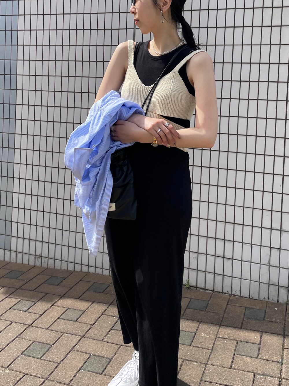 ブラック系のワンピース、ホワイト系のニット/セーター、ホワイト系のスニーカーを着用したレディースの夏コーディネートの5枚目の写真
