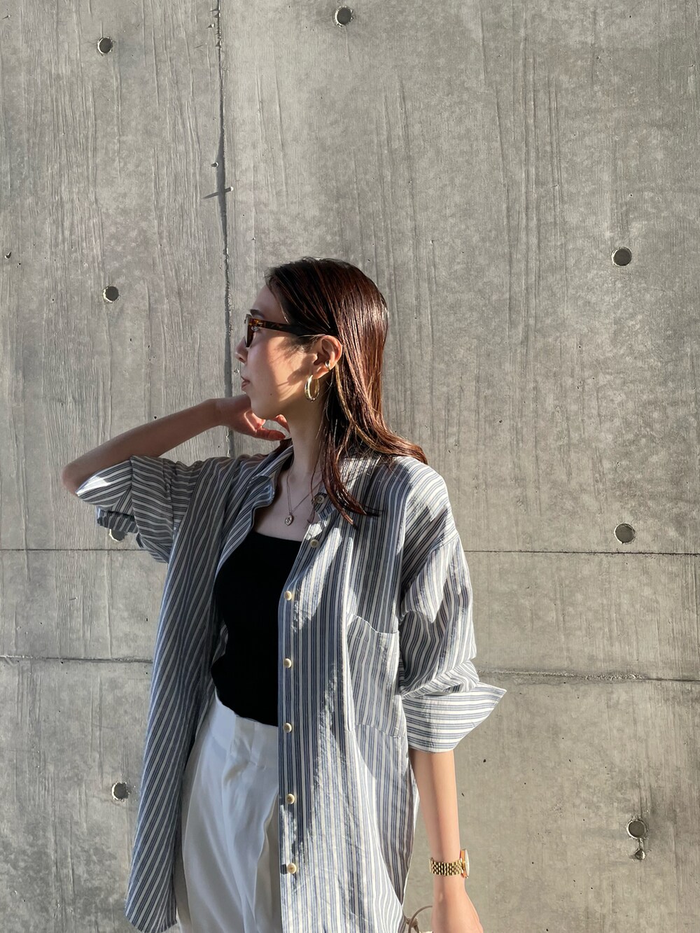 ブラック系のキャミソール、ブルー系のシャツ/ブラウス、ベージュ系のハンドバッグを着用したレディースの春コーディネートの5枚目の写真