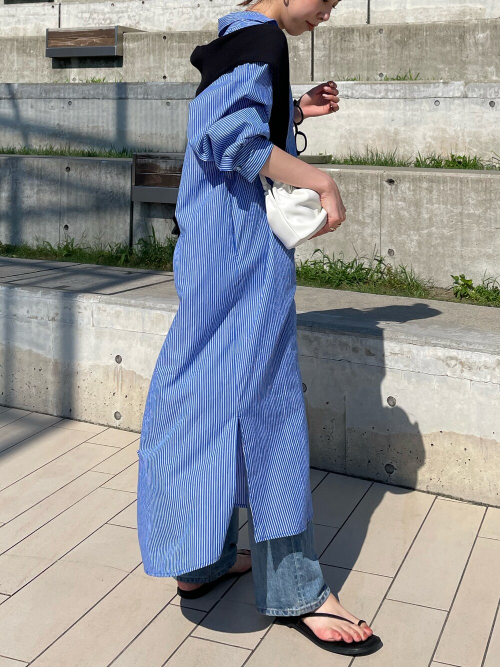ブルー系のワンピース、ホワイト系のハンドバッグ、ブラック系のサンダルを着用したレディースの夏コーディネートの3枚目の写真