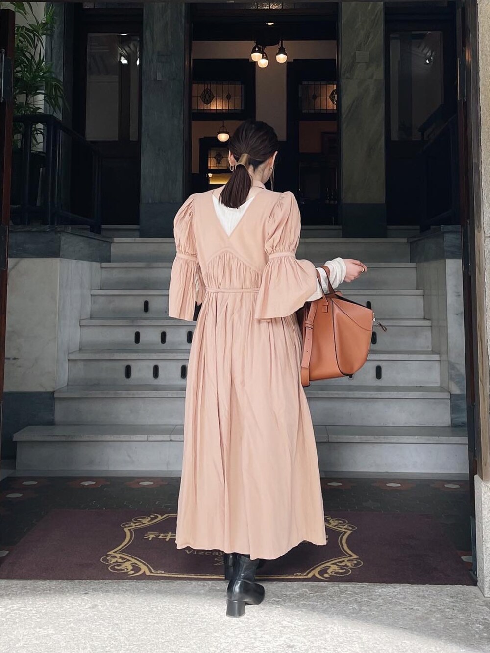 ベージュ系のワンピース、ブラウン系のハンドバッグを着用したレディースの春コーディネートの4枚目の写真