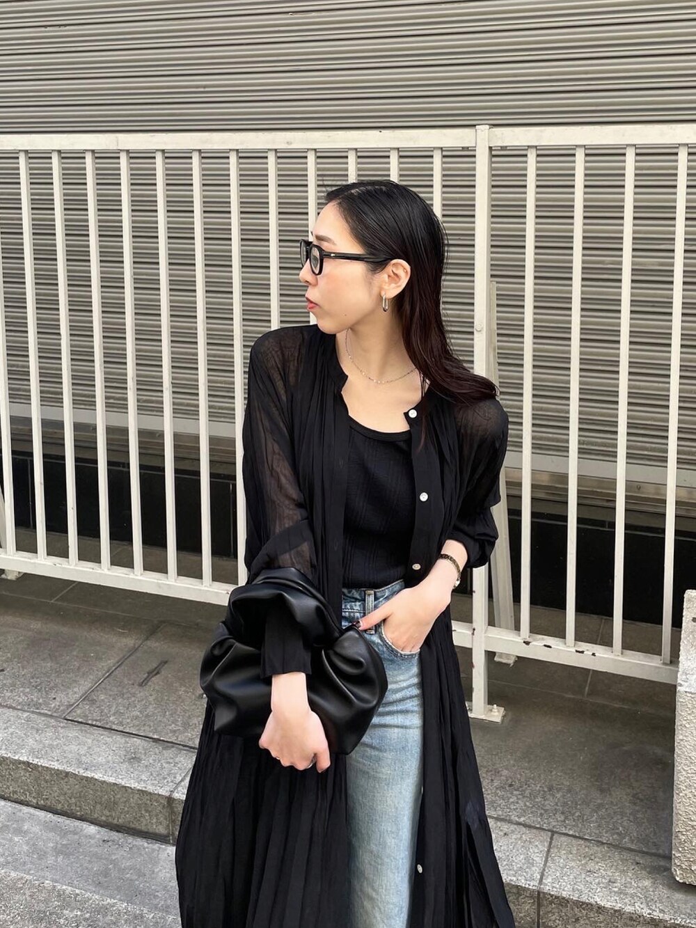 ブラック系のパンプス、ブルー系のデニムパンツ、ブラック系のタンクトップを着用したレディースの春コーディネートの4枚目の写真