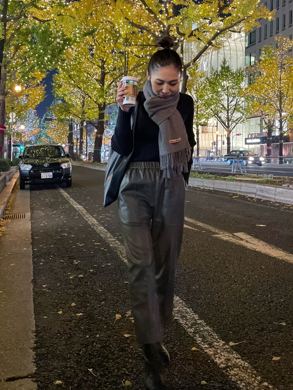 ブラック系のブーツ、ブラック系のニット/セーター、ブラック系のハンドバッグを着用したレディースの秋コーディネートの2枚目の写真