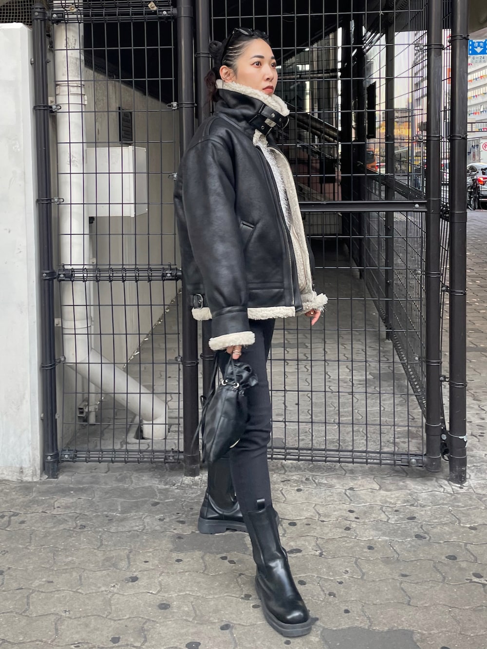 ブラック系のショルダーバッグ、ブラック系のデニムパンツ、シルバー系のニット/セーターを着用したレディースの秋コーディネートの2枚目の写真