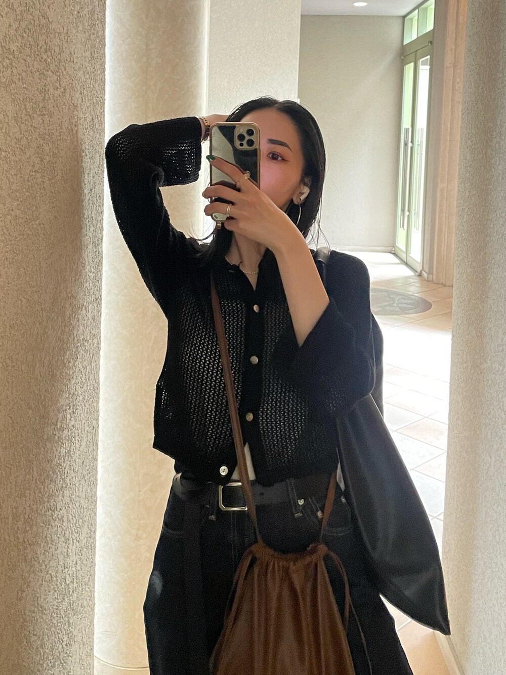 グレー系のサンダル、ブルー系のデニムパンツ、ブラック系のカーディガン/ボレロを着用したレディースの夏コーディネートの5枚目の写真