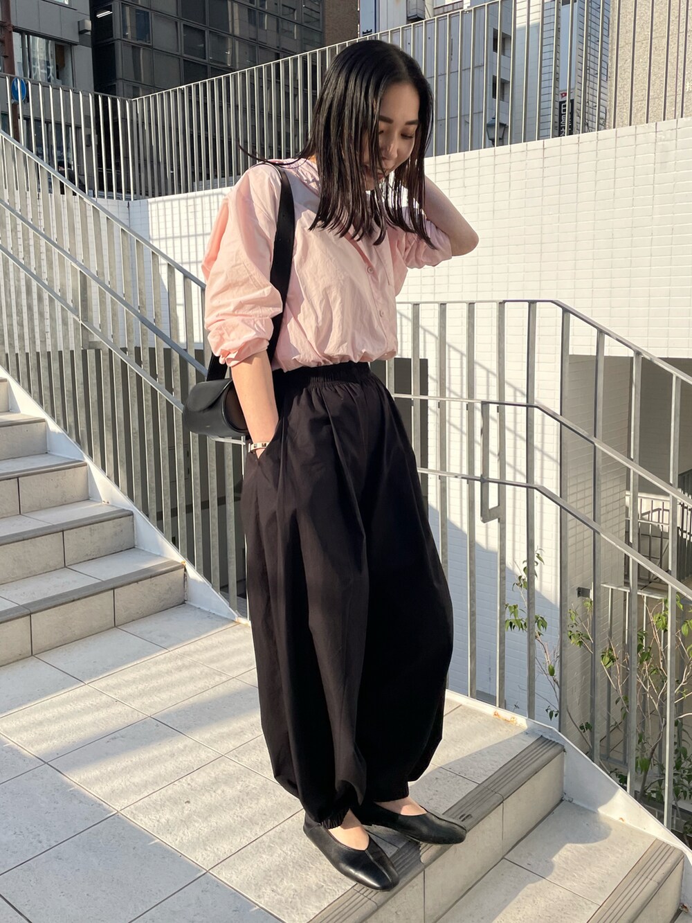 ピンク系のシャツ/ブラウス、ブラック系のその他パンツ、ブラック系のショルダーバッグを着用したレディースの春コーディネートの2枚目の写真